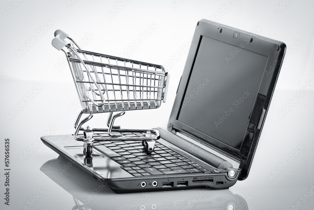 Online shopping. Shopping cart with notebook on the white. shopp Online shopping. Shopping cart with notebook on the white. shopp