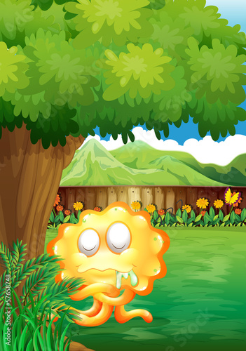 A yellow monster under the tree in the gated yard