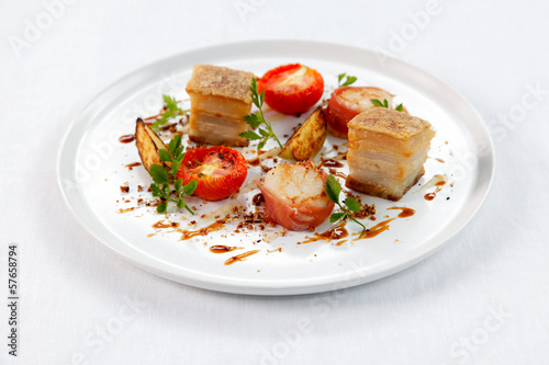 Sliced roast pork belly on a plate .