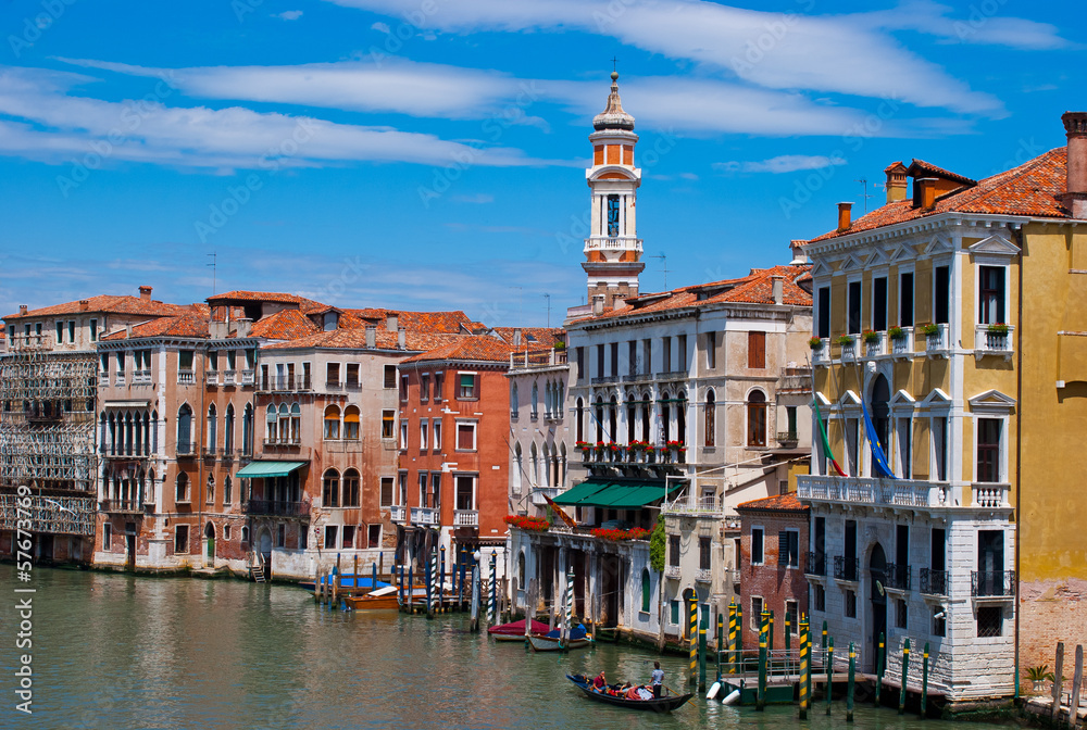 Famous buildings, gondolas and monuments by the Rialto Bridge of Venice on the Grand Canal.  Tourists place