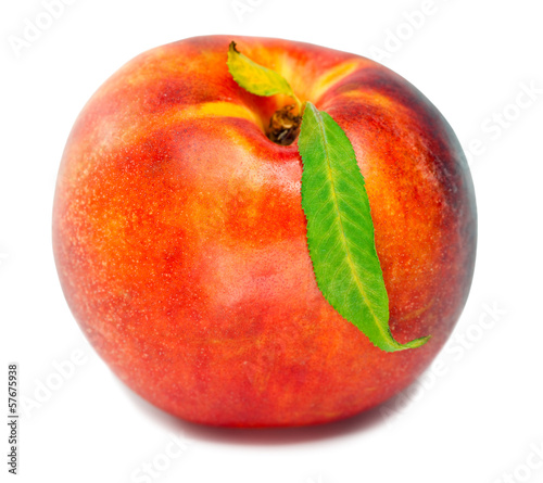Ripe nectarine with a green leaf on a white background..