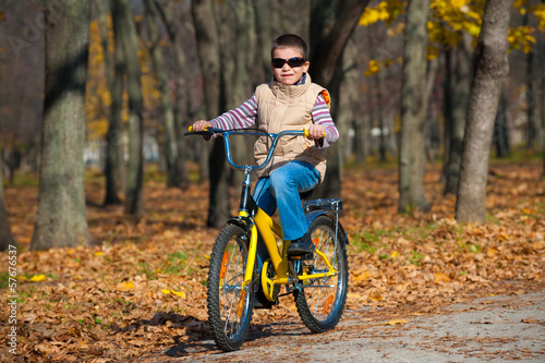 boy rides a bicycle in park photo