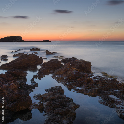 Stunning landscapedawn sunrise with rocky coastline and long exp
