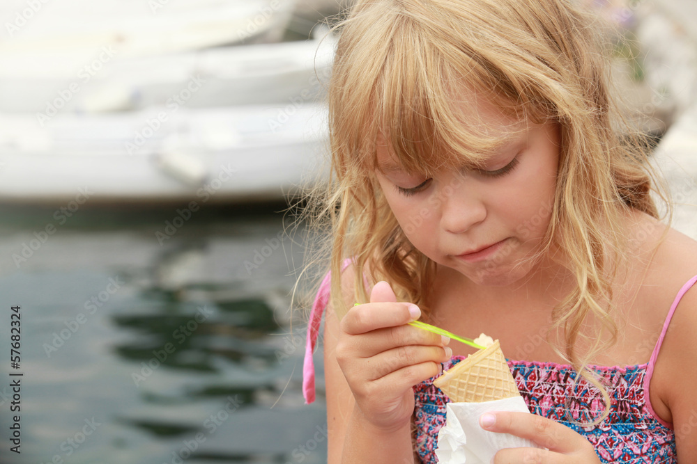 Little blond girl eats ice cream. Outdoor portrait Little blond girl eats ice cream. Outdoor portrait