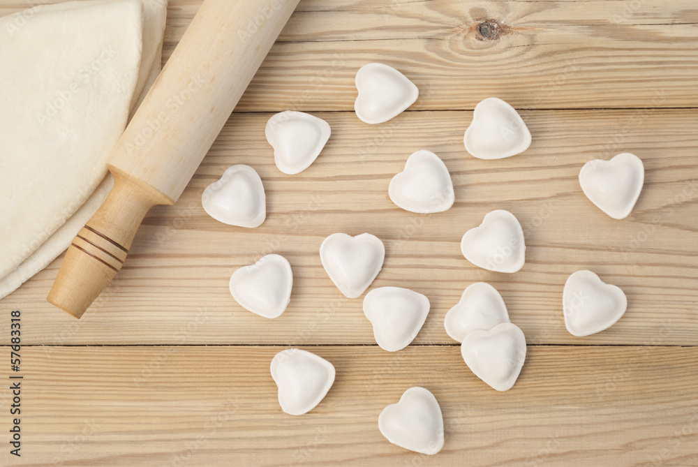 Dumplings in a heart shape dough and rolling pin. Dumplings in a heart shape dough and rolling pin.