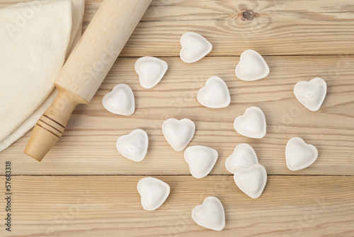 Dumplings in a heart shape dough and rolling pin.