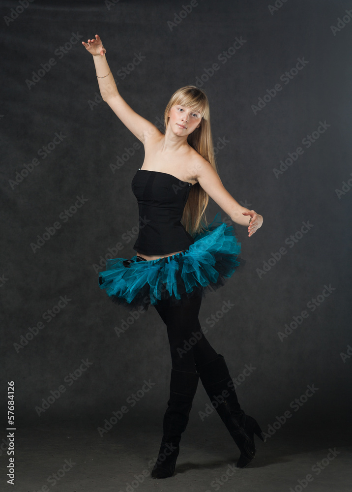 young beautiful dancer with blond hair dancing on a dark studio