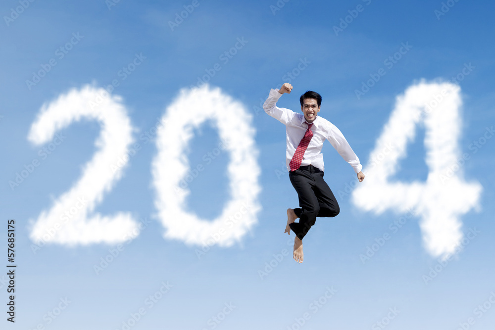 Happy businessman jumps with clouds of 2014