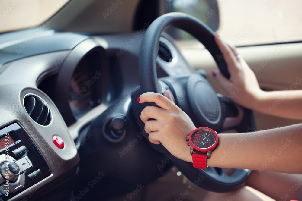 Close-up of a woman's hand on steering wheel in a modern car