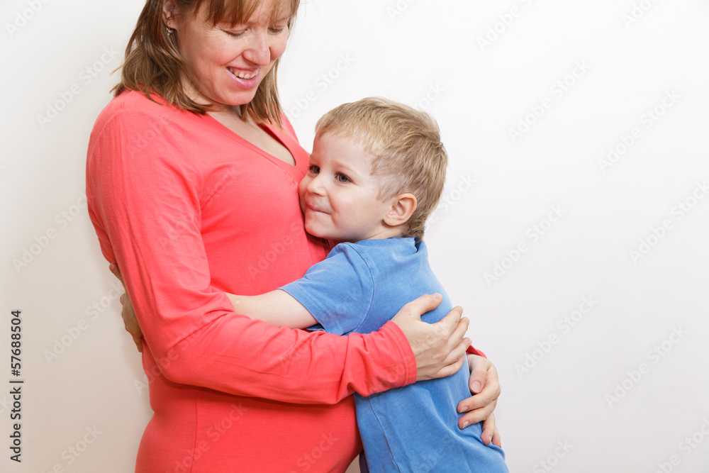 cute little boy embracing his pregnant mother cute little boy embracing his pregnant mother