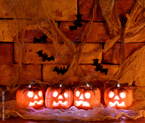 Four shining pumpkins in the dark photo