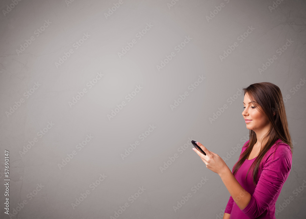 young lady standing and holding a phone with copy space young lady standing and holding a phone with copy space