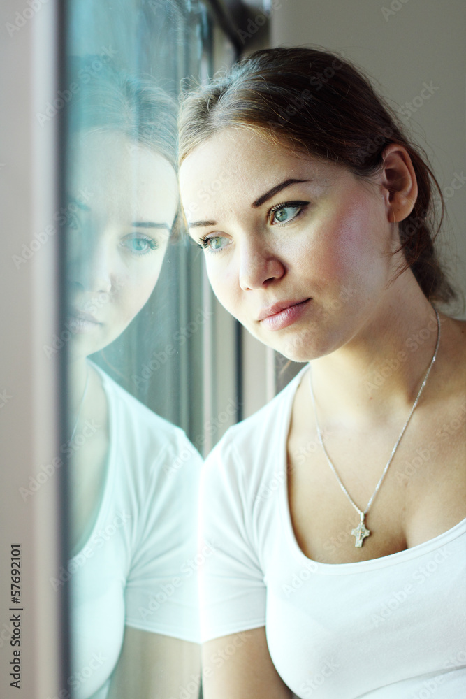 beautiful woman sitting in front of the window