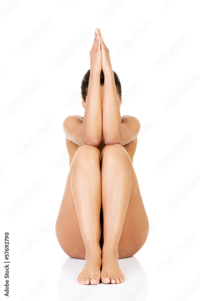 Beautiful naked woman sitting with her arms and legs togheter. Stock Photo  | Adobe Stock