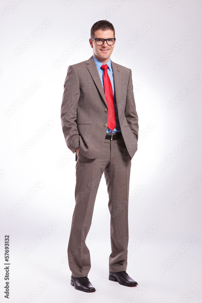 young business man smiles with both hands in pockets young business man smiles with both hands in pockets