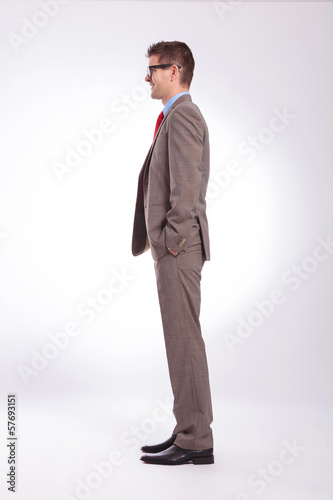 side of young business man with hands in pockets