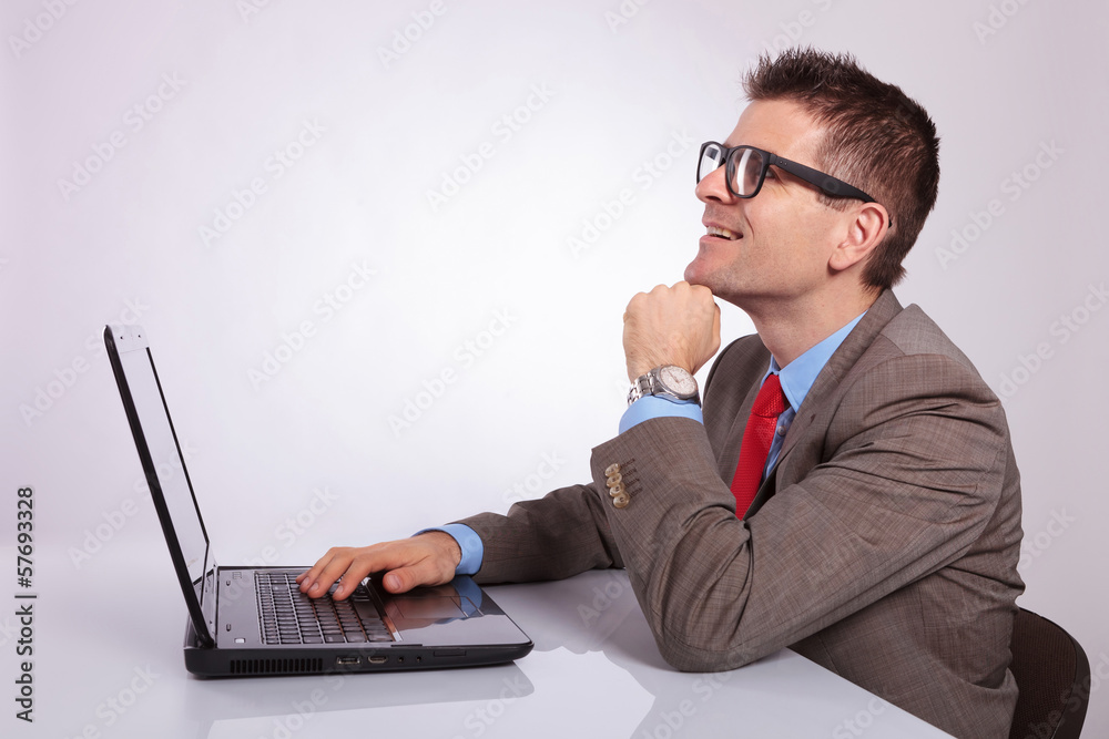 side of young business man with laptop, looking up with hand on side of young business man with laptop, looking up with hand on