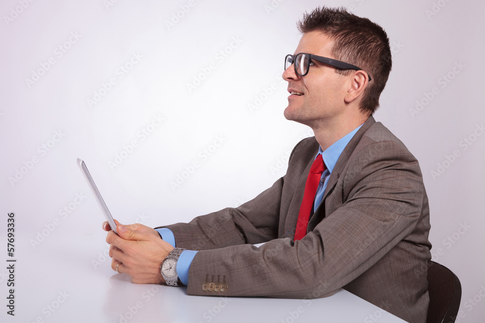 side of young business man with tablet, looking up side of young business man with tablet, looking up