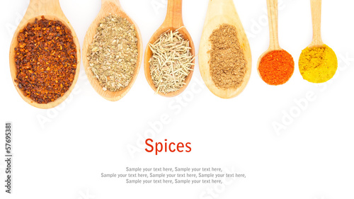 Spices in spoons on white