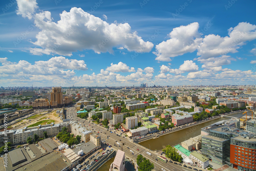 Beautiful cityscape with river, blue sky and clouds.