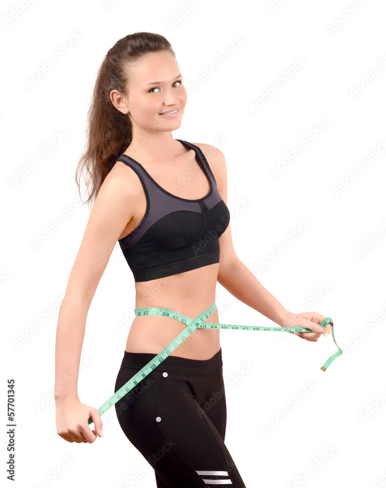 Fit girl measuring her waist with a measuring tape in inch Fit girl measuring her waist with a measuring tape in inch