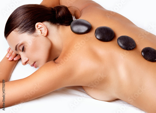 Stone Massage. Beautiful Woman Getting Spa Hot Stones Massage in