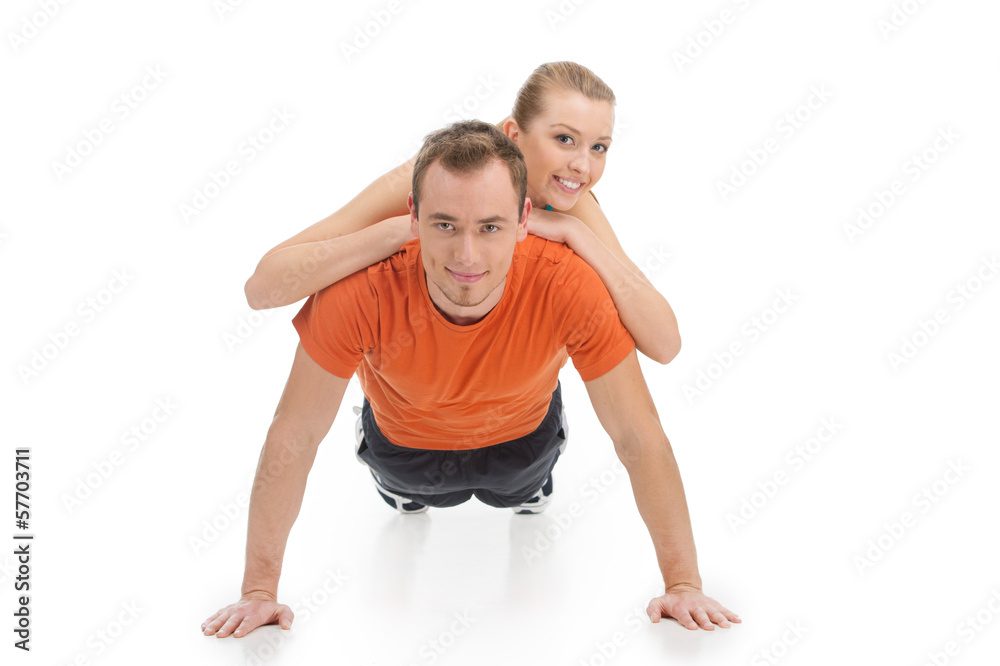 Handsome man exercising with beautiful woman on his back. Handsome man exercising with beautiful woman on his back.