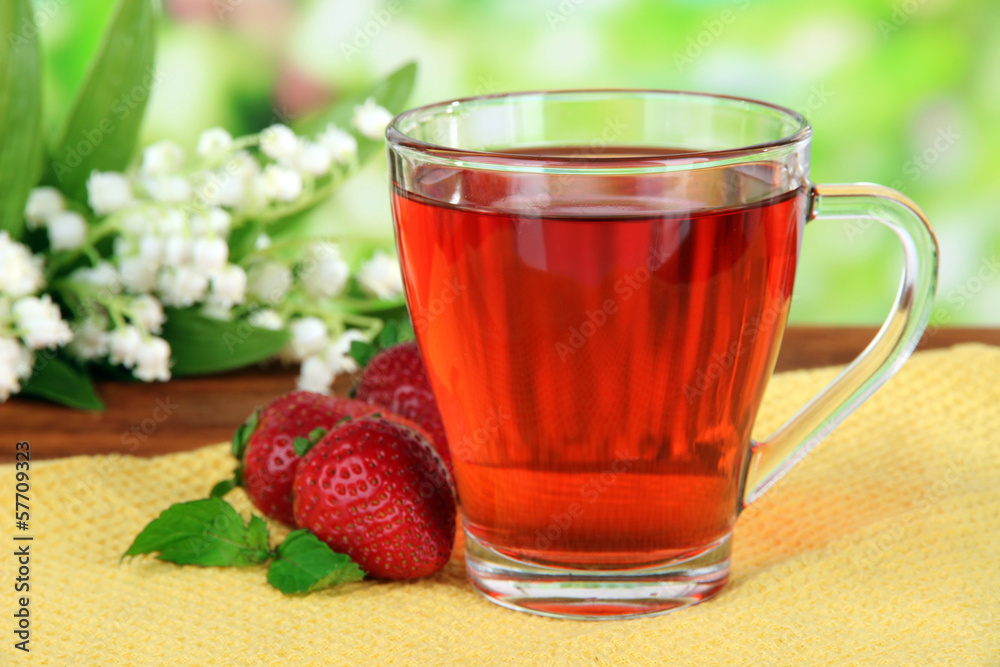 Delicious strawberry tea on table on bright background Delicious strawberry tea on table on bright background