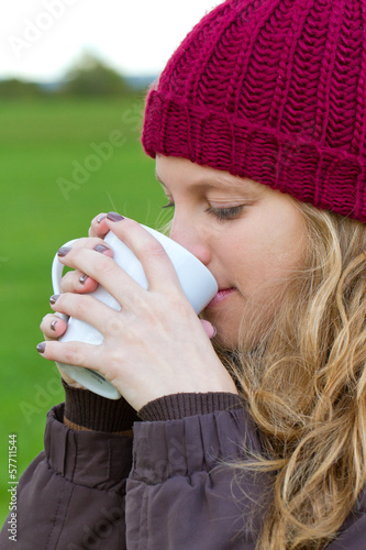 Junge Frau mit einem Heißgetränk in der Natur photo