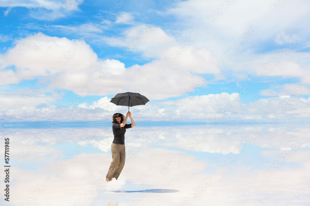 Woman jumping with umbrella on lake Uyuni, Bolivia Woman jumping with umbrella on lake Uyuni, Bolivia