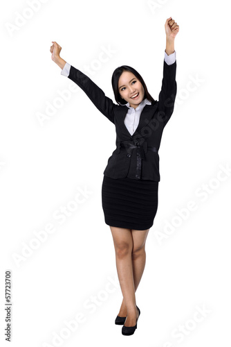 Confident business woman standing full length in black suit.