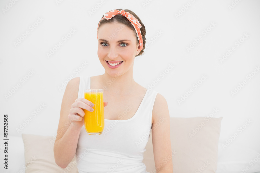 Smiling woman holding a glass of orange juice Smiling woman holding a glass of orange juice