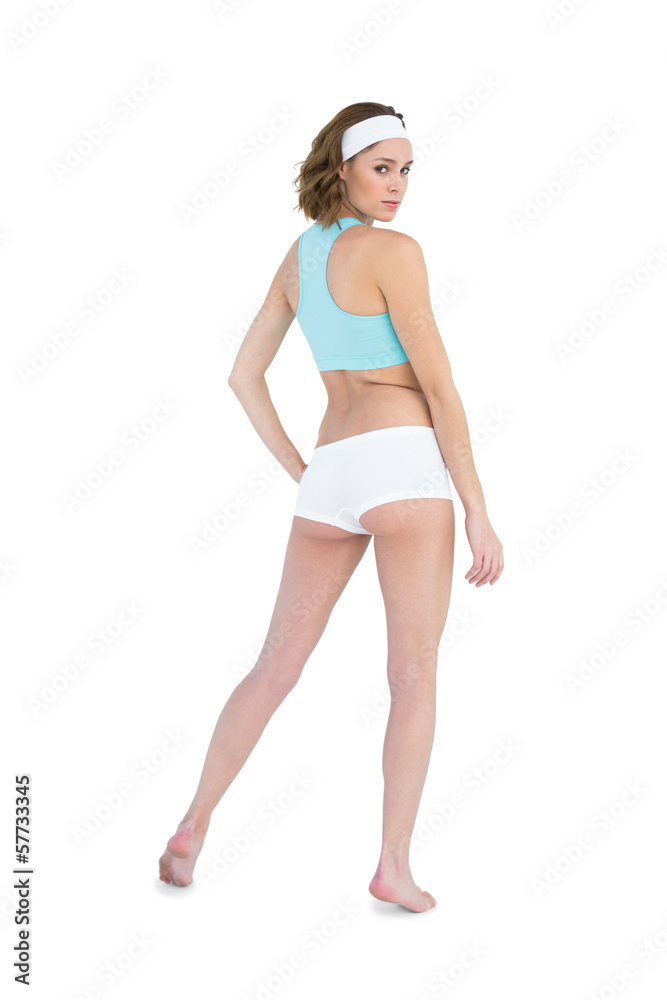 Serious slender woman wearing sportswear posing with hand on hip Serious slender woman wearing sportswear posing with hand on hip