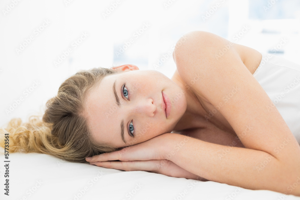 Pretty content blonde lying in bed looking at camera Pretty content blonde lying in bed looking at camera