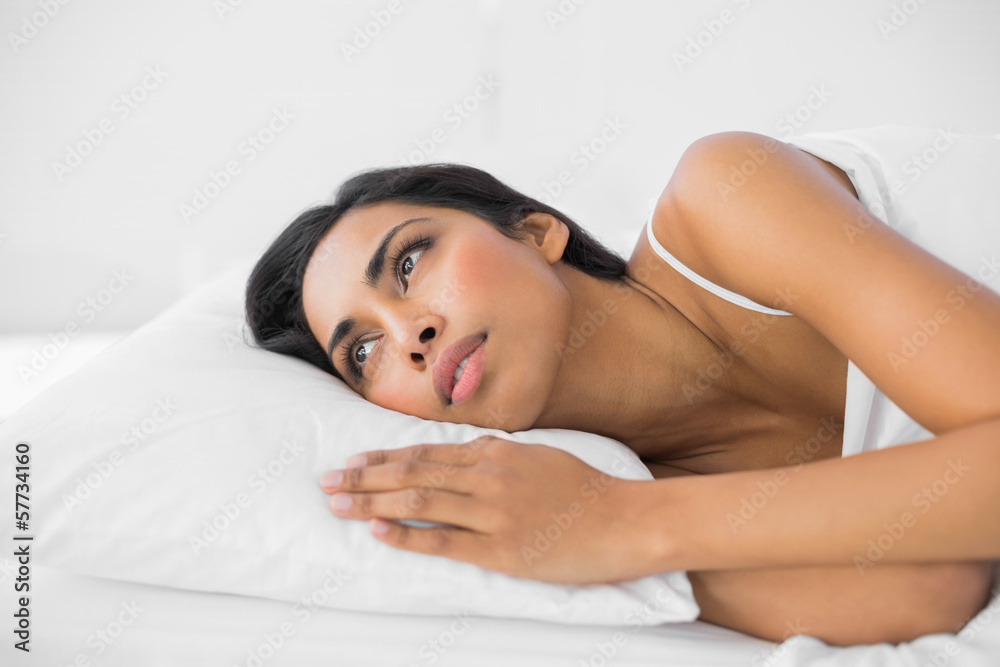 Peaceful serious woman lying relaxing on her bed Peaceful serious woman lying relaxing on her bed