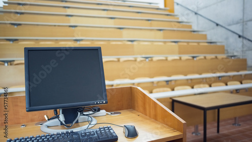 Computer monitor with empty seats in a lecture hall