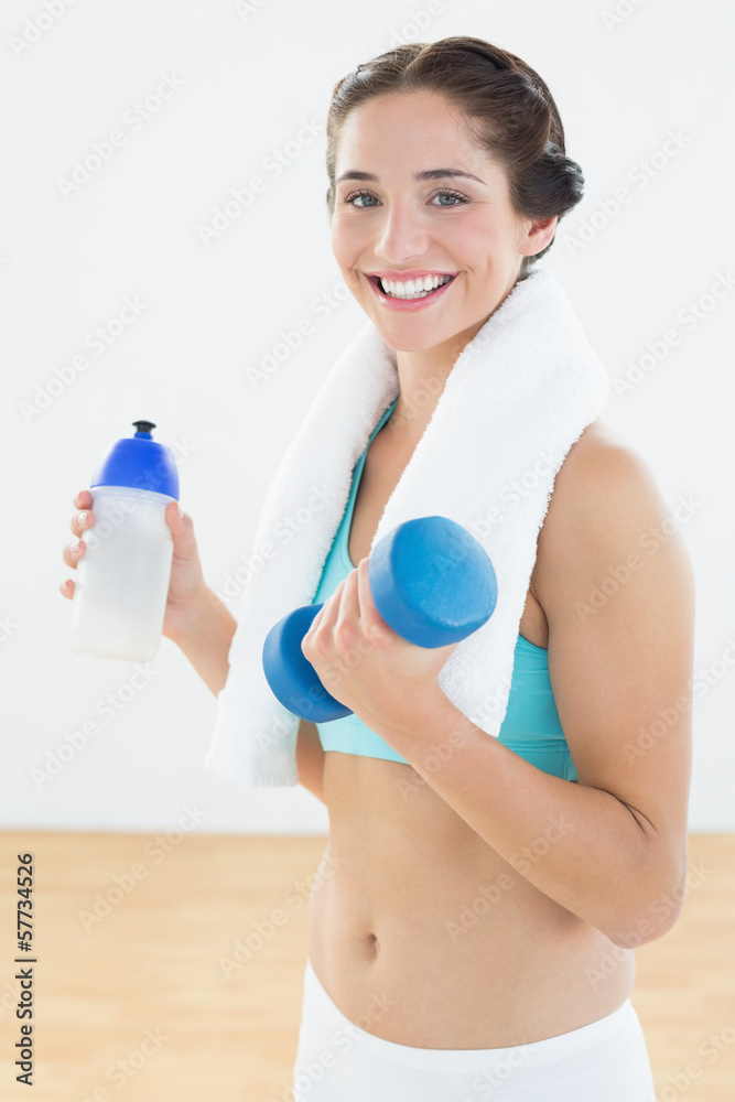 Woman with dumbbells and water bottle at fitness studio Woman with dumbbells and water bottle at fitness studio