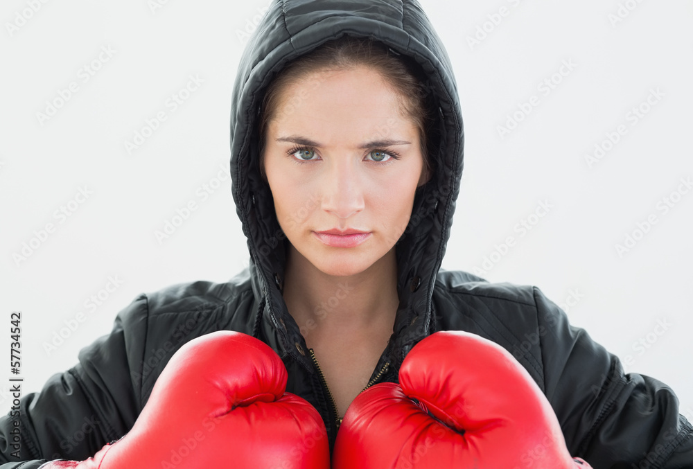 Serious woman in red boxing gloves and black hood Serious woman in red boxing gloves and black hood