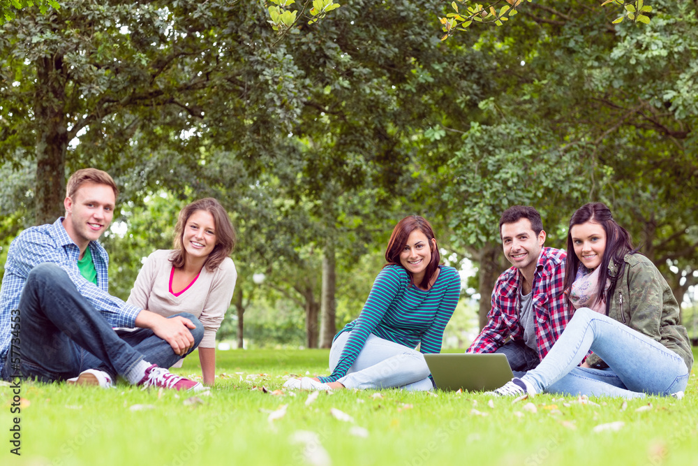 Young college students using laptop in the park Young college students using laptop in the park