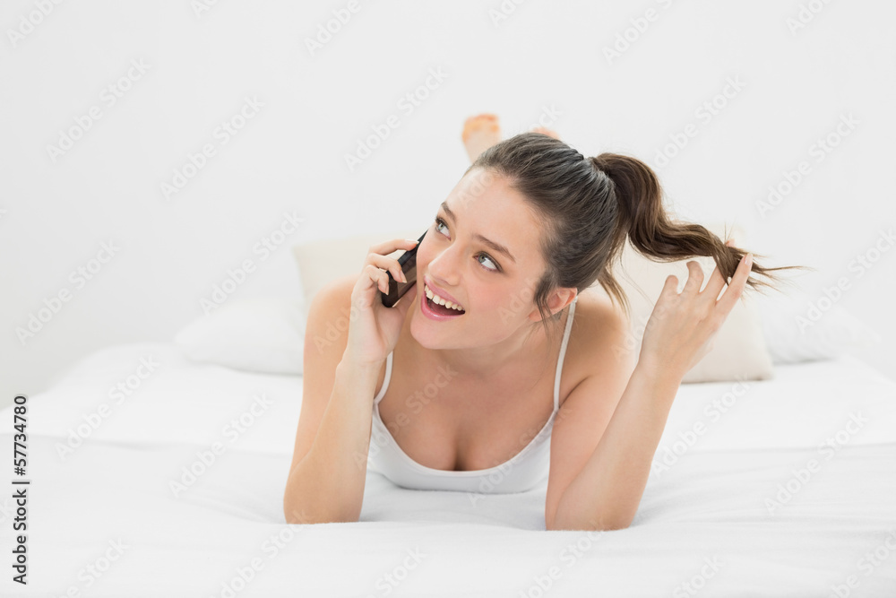 Cheerful casual woman using mobile phone in bed Cheerful casual woman using mobile phone in bed