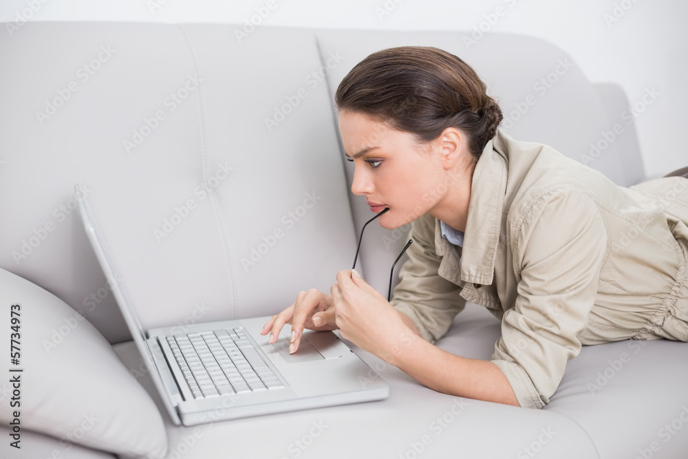 Beautiful woman using laptop on sofa at home Beautiful woman using laptop on sofa at home