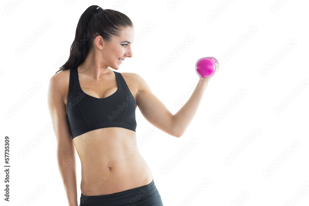 Cheerful slender woman training her arm using a pink dumbbell Cheerful slender woman training her arm using a pink dumbbell