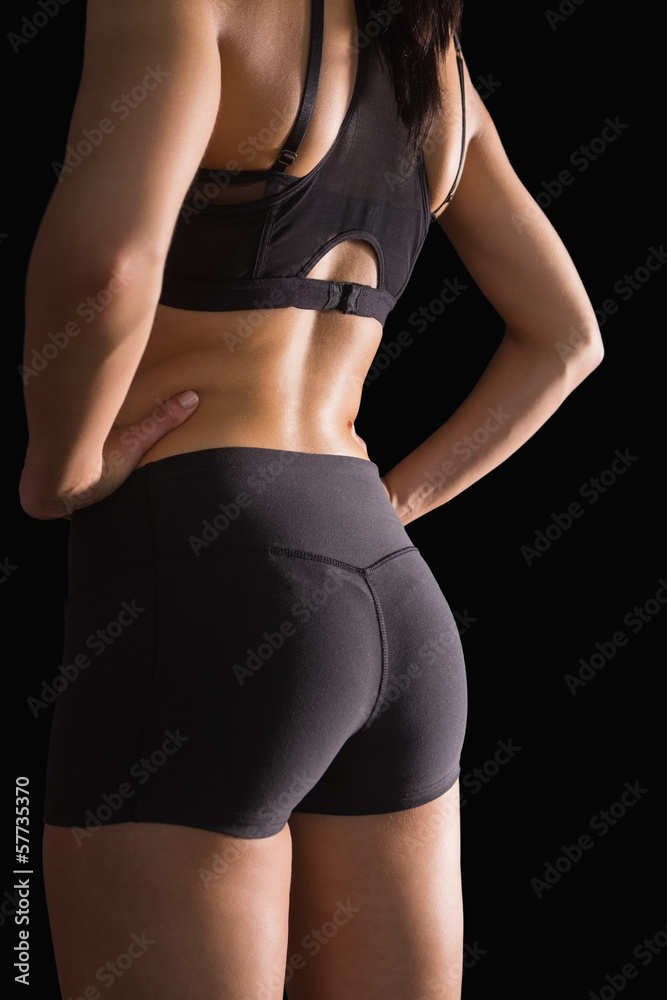 Mid section of the backside of young slim woman wearing sportswe Mid section of the backside of young slim woman wearing sportswe