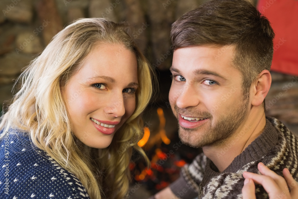 Romantic couple smiling in front of fireplace Romantic couple smiling in front of fireplace
