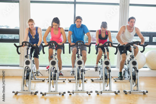 Determined people working out at spinning class in gym