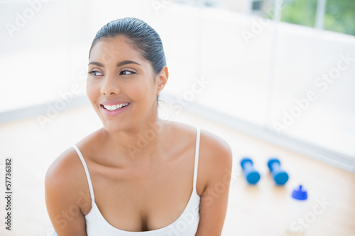 Happy toned brunette sitting on floor Free Download Happy toned brunette sitting on floor - GFXLoad