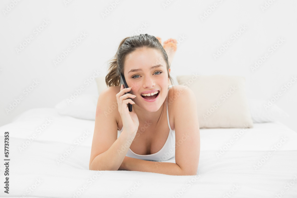 Portrait of a casual woman using mobile phone in bed Portrait of a casual woman using mobile phone in bed