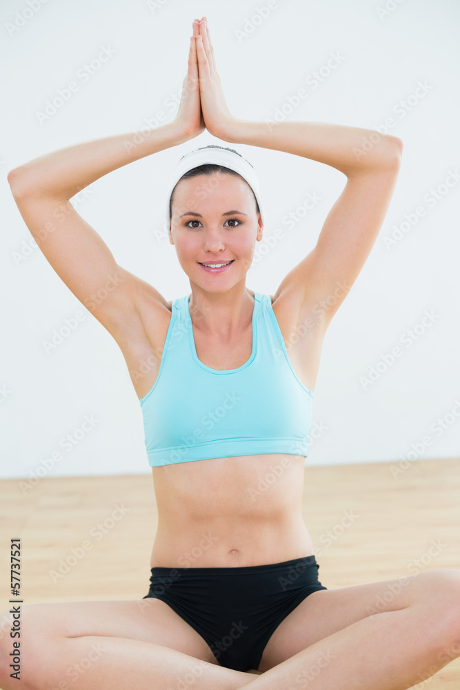 Smiling woman with joined hands over head at fitness studio Smiling woman with joined hands over head at fitness studio