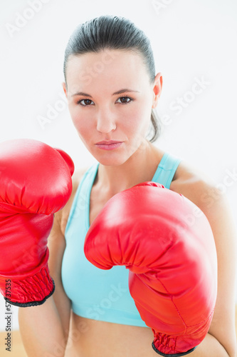 Close-up portrait of a beautiful woman in red boxing gloves