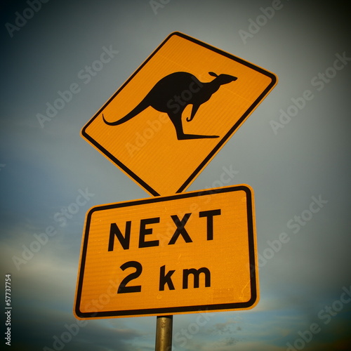 A yellow road sign of danger with a kangaroo in Australia.